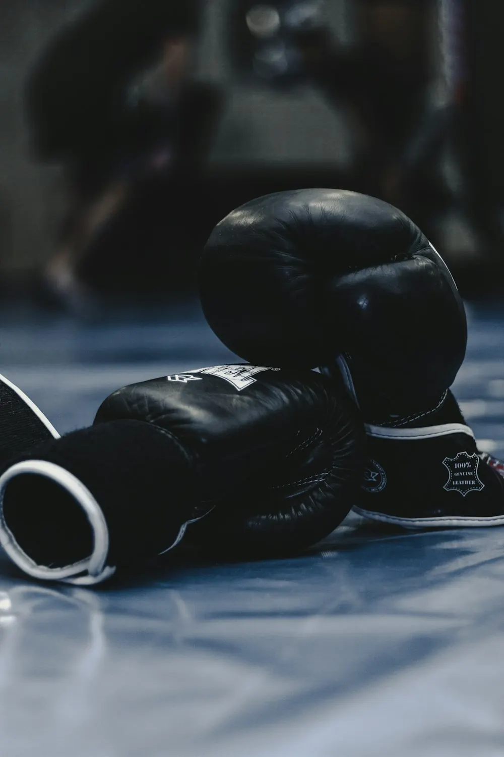 Pair of black boxing gloves resting on the floor